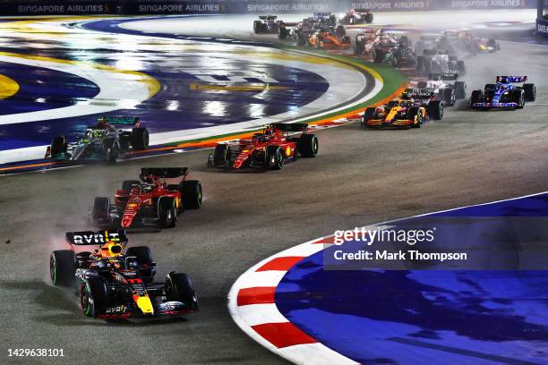 Sergio Perez of Mexico driving the Oracle Red Bull Racing RB18 leads Charles Leclerc of Monaco driving the Ferrari F1-75 and the rest of the field at...