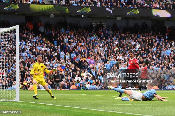 Erling Haaland of Manchester City scores their sides third goal past David De Gea of Manchester United during the Premier League match between...