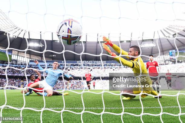 Phil Foden of Manchester City scores their sides fourth goal past David De Gea of Manchester United during the Premier League match between...