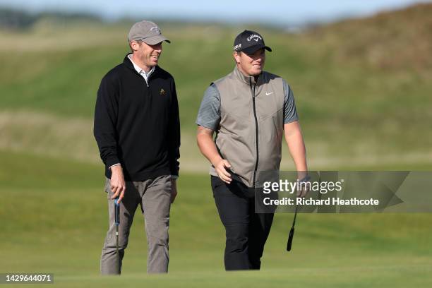 Callum Shinkwin of England and their playing partner, Alex Acquavella interact on the 12th green on Day Four of the Alfred Dunhill Links Championship...