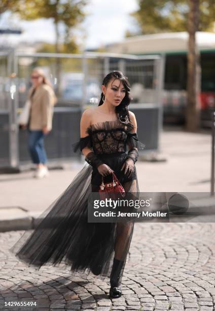 Jessica Wang seen wearing a black transparent dress and a Giambattista Valli red bag, outside Giambattista Valli during Paris Fashion Week on...