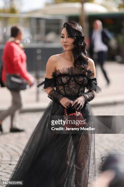 Jessica Wang seen wearing a black transparent dress and a Giambattista Valli red bag, outside Giambattista Valli during Paris Fashion Week on...