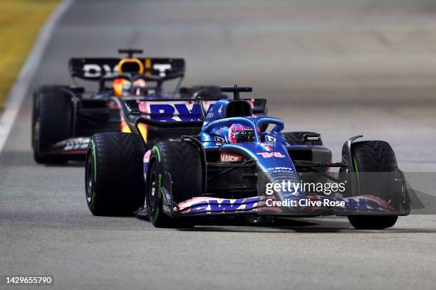 Fernando Alonso of Spain driving the Alpine F1 A522 Renault leads Max Verstappen of the Netherlands driving the Oracle Red Bull Racing RB18 during...