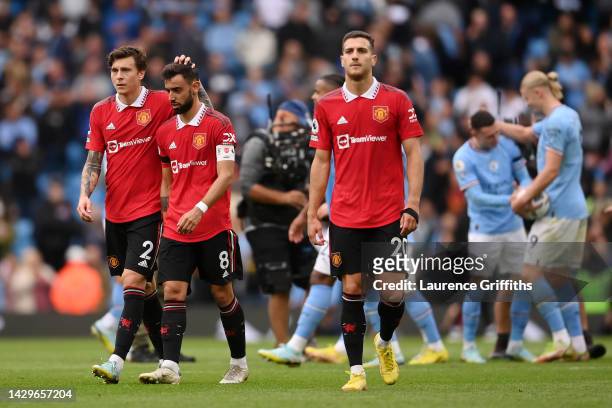 Victor Lindelöf, Bruno Fernandes and Diogo Dalot of Manchester United cut dejected figures following the Premier League match between Manchester City...