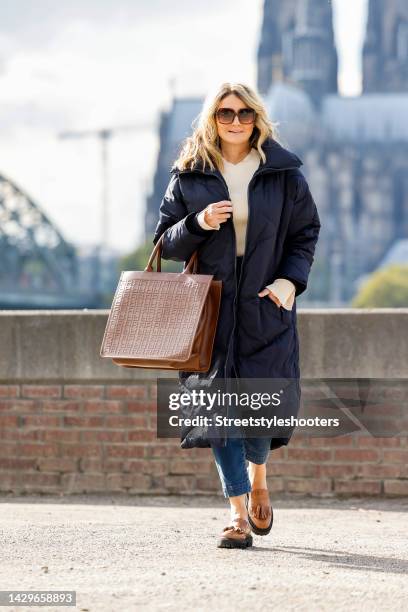 German TV host Frauke Ludowig, wearing a dark blue coat by Riani, a white knitted tutleneck by Riani, a Jeans by riani, a brown leather shopper bag...