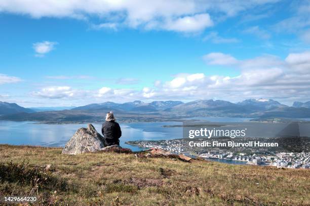 woman with grey hair enjoing the view over tromsø in norther norway - finn bjurvoll stockfoto's en -beelden