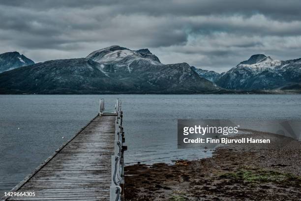 pier in a norwegian fjord near tromsø in northern norway - finn bjurvoll stockfoto's en -beelden