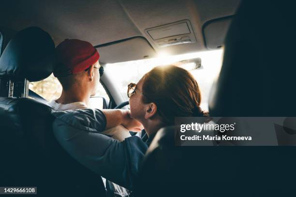 couple enjoying the car ride at sunset. - pareja de mediana edad fotografías e imágenes de stock