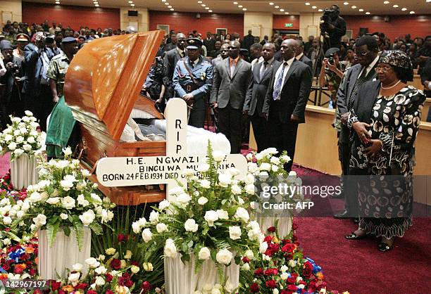 Malawi's President Joyce Banda, , standing next to her husband, retitred Chief Justice Richard Banda, leads people in paying their last respects to...