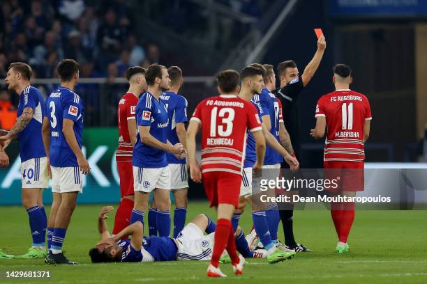 Mërgim Berisha of Augsburg is shown a red card Match Referee Daniel Schlager during the Bundesliga match between FC Schalke 04 and FC Augsburg at...