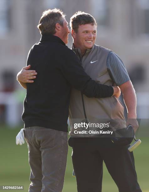 Callum Shinkwin of England and their playing partner, Alex Acquavella embrace on the 18th green on Day Four of the Alfred Dunhill Links Championship...