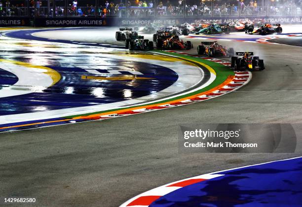 Sergio Perez of Mexico driving the Oracle Red Bull Racing RB18 leads Charles Leclerc of Monaco driving the Ferrari F1-75 and the rest of the field at...