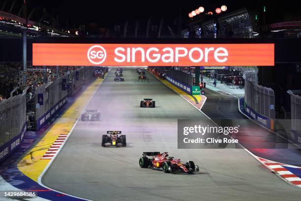 Charles Leclerc of Monaco driving the Ferrari F1-75 leads Sergio Perez of Mexico driving the Oracle Red Bull Racing RB18 and the rest of the field on...