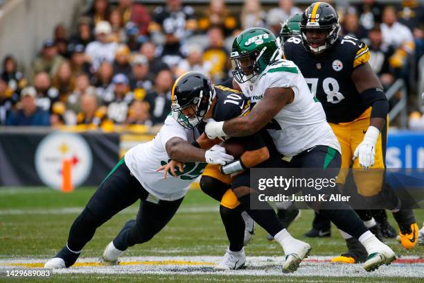 Mitch Trubisky of the Pittsburgh Steelers runs with the ball while being tackled by Quinnen Williams and John Franklin-Myers of the New York Jets in...