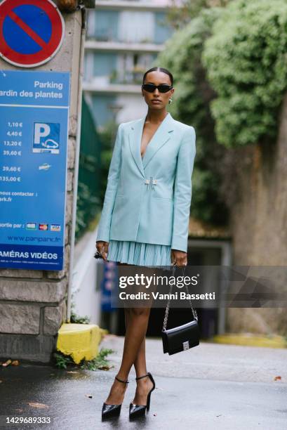 Jasmine Tookes poses wearing a Givenchy light blue U-lock closed jacket and a Givenchy bag after the Givenchy show during Paris Fashion Week -...