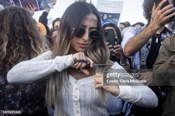 Woman cuts her hair during a protest against the death of Iranian Mahsa Amini and the government of Iran on October 02, 2022 in Istanbul, Turkey....