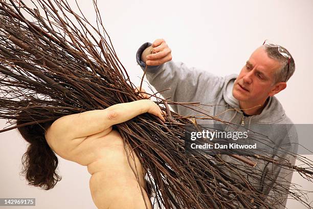 Artist Ron Mueck puts the finishing touches to his piece 'Woman with Sticks' at the Hauser & Wirth gallery on April 16, 2012 in London, England. The...