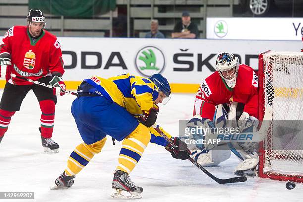 Ukrainian Vitali Donka vies with Bence Balizs of Hungary during the 2012 IIHF Ice Hockey World Championship Divison I, Group A match, between Hungary...