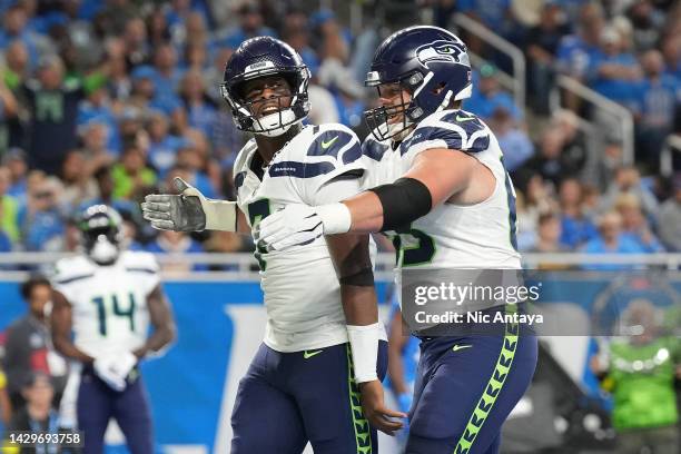 Geno Smith of the Seattle Seahawks celebrates alongside Boye Mafe after making a touchdown during the first quarter of the game against the Detroit...