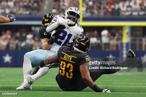 Cole Holcomb of the Washington Commanders and Jonathan Allen of the Washington Commanders tackle Ezekiel Elliott of the Dallas Cowboys during the...