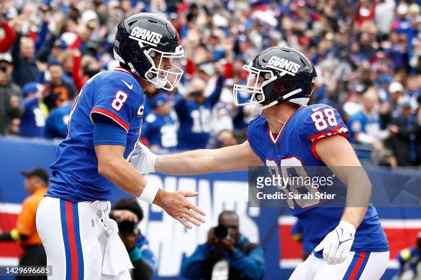 Daniel Jones of the New York Giants celebrates a touchdown with Tanner Hudson in the first quarter of the game against the Chicago Bears at MetLife...