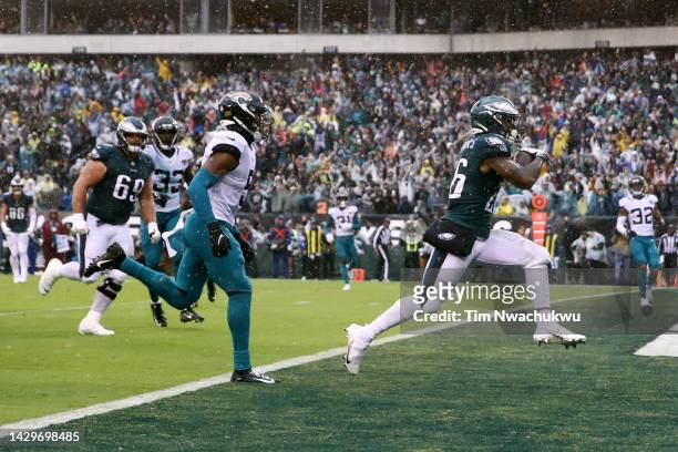 Miles Sanders of the Philadelphia Eagles runs past Andre Cisco of the Jacksonville Jaguars while scoring a touchdown during the second quarter at...