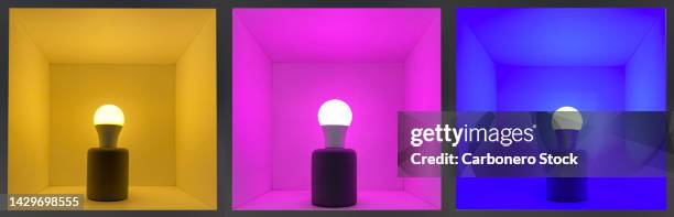 3 colored led bulbs lit inside presentation boxes - energy efficient lightbulb stock-fotos und bilder