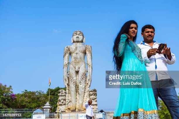 a couple next to the bahubali (gomateshwara) at ratnagiri hill. - digambara stock-fotos und bilder