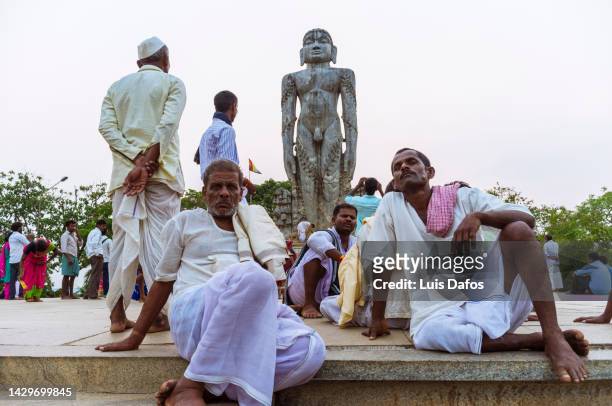 pilgrims next to the bahubali (gomateshwara) statue at ratnagiri hill. - digambara stock-fotos und bilder