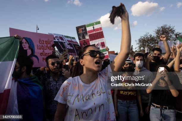 Woman cuts her hair during a protest against the death of Iranian Mahsa Amini and the government of Iran on October 02, 2022 in Istanbul, Turkey....