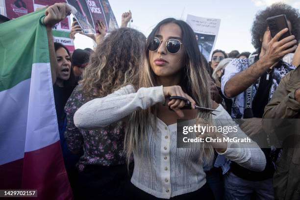 Woman cuts her hair during a protest against the death of Iranian Mahsa Amini and the government of Iran on October 02, 2022 in Istanbul, Turkey....