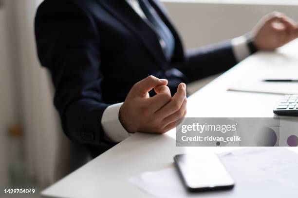 close up of a businessman exercising yoga in lotus position. - office zen stock pictures, royalty-free photos & images