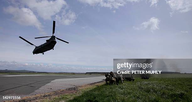 Soldiers from The Royal Regiment of Scotland take cover as a Chinook helicopter takes off during the 16 Air Assault Brigade Exercise Joint Warrior at...