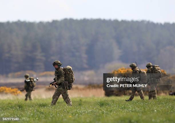 Soldiers from The Royal Regiment of Scotland move through a field during the 16 Air Assault Brigade Exercise Joint Warrior at West Freugh Airfield,...