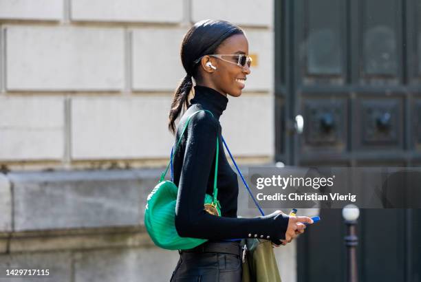 Guest wears green bag outside Loewe during Paris Fashion Week - Womenswear Spring/Summer 2023 : Day Five on September 30, 2022 in Paris, France.