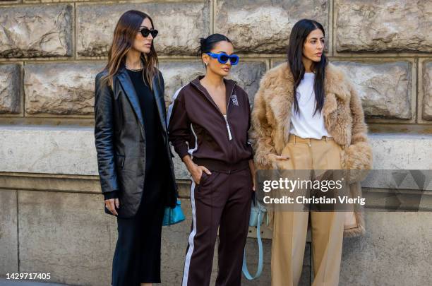 Giorgia Tordini wears black leather blazer, black dress, silver heels & Amina Muaddi wears blue sunglasses, brown track suit with logo& Gilda...