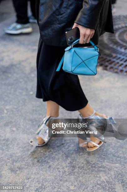 Giorgia Tordini wears black leather blazer, black dress, silver heels, blue bag outside Loewe during Paris Fashion Week - Womenswear Spring/Summer...