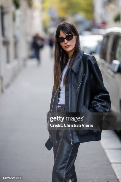 Leia Sfez wears black bomber jacket, leather pants, sandals, white shirt outside Victoria Beckham during Paris Fashion Week - Womenswear...