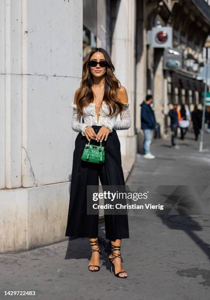 Tamara Kalinic wears black high waisted dress, green bag, white off shoulder blouse outside Giambattista Valli during Paris Fashion Week - Womenswear...