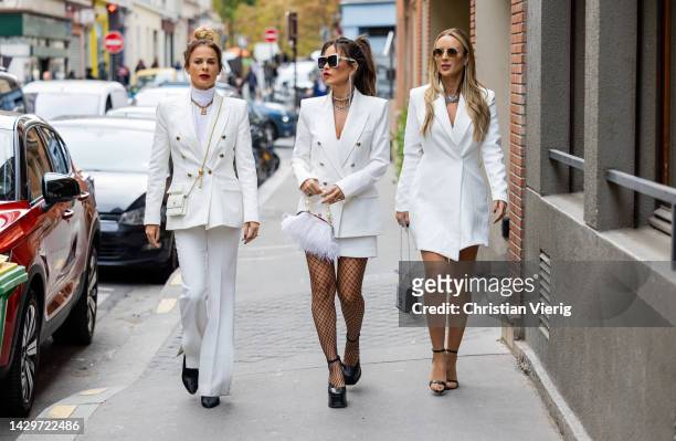 Guests wears white double breasted blazer, pants, skirt, net tights outside during Paris Fashion Week - Womenswear Spring/Summer 2023 : Day Five on...