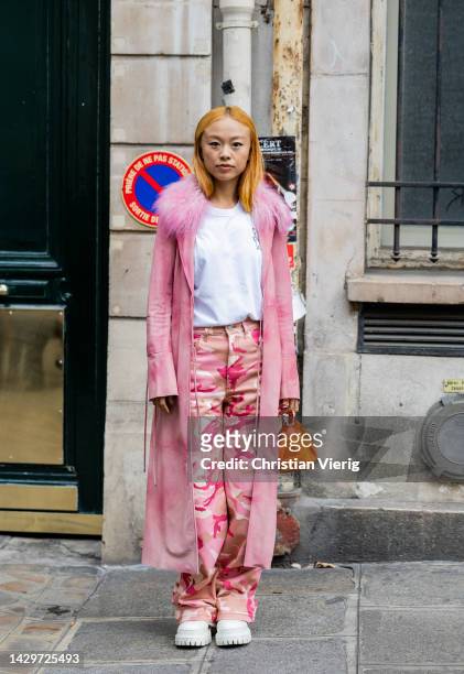 Niki Wu Jie wears rose coat, pants with print, orange bag, white shirt outside Ottolinger Paris Fashion Week - Womenswear Spring/Summer 2023 : Day...