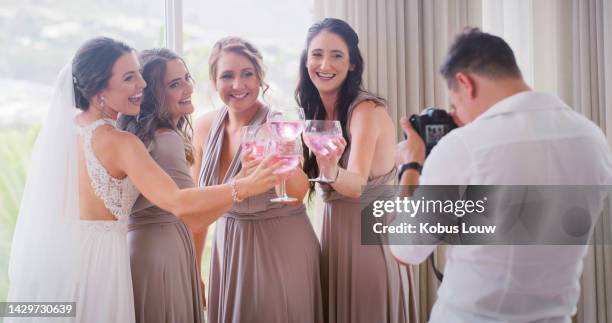 bride giving toast with bridesmaids and wedding photographer, happy with alcohol at marriage reception and excited about ceremony with friends. professional camera man taking photo of bridal party - wedding photographer stock pictures, royalty-free photos & images