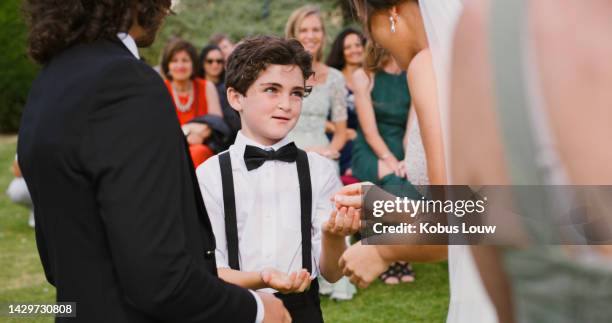 child with ring at wedding, woman bride hand and happy smile people. garden event, bride and groom promise love ring exchange with family together at outdoor ceremony and page boy, cute ring bearer - ring bearer stockfoto's en -beelden