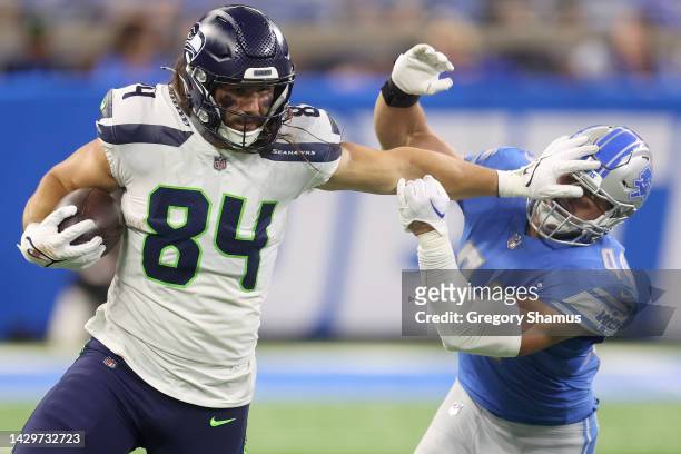 Colby Parkinson of the Seattle Seahawks stiff arms Malcolm Rodriguez of the Detroit Lions during the fourth quarter at Ford Field on October 02, 2022...