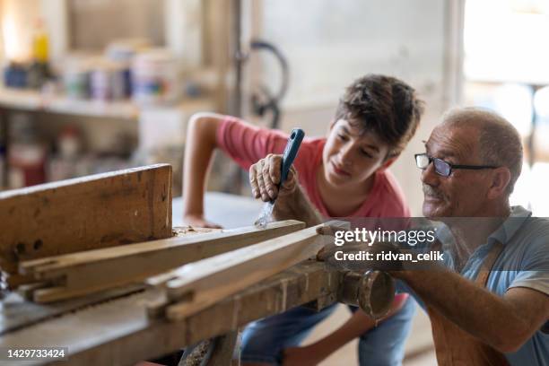 grandfather and grandson in workshop - grandpa son stock pictures, royalty-free photos & images
