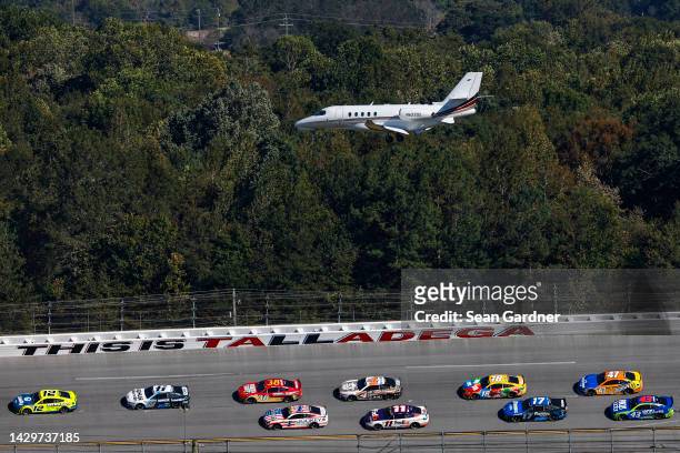Ryan Blaney, driver of the Menards\Dutch Boy Ford, leads the field as a plane lands during the NASCAR Cup Series YellaWood 500 at Talladega...
