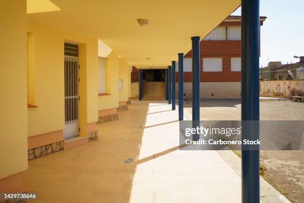 porch, next to the schoolyard, which connects different school buildings and gives access to different classrooms. - patio de colegio fotografías e imágenes de stock