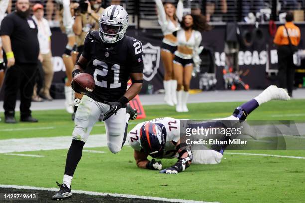 Amik Robertson of the Las Vegas Raiders avoids a tackle by Garett Bolles of the Denver Broncos to score a 68-yard touchdown after recovering a fumble...