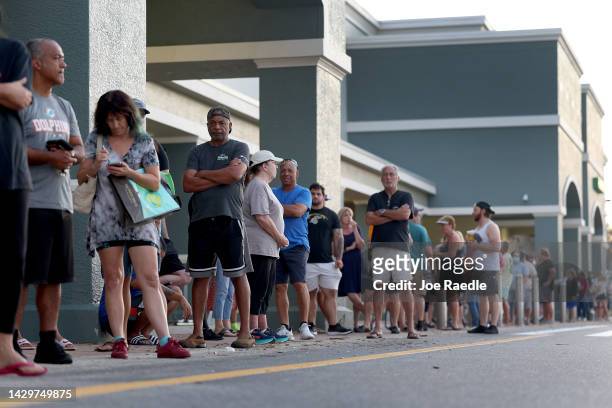 People lineup as they wait for the Publix supermarket to open after hurricane Ian passed through the area on October 2, 2022 in Cape Coral, Florida....