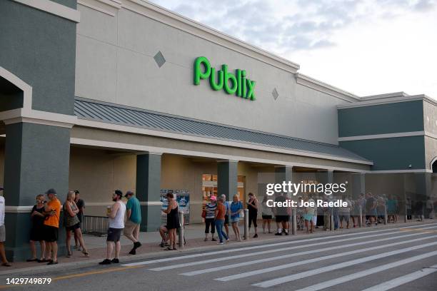 People line up as they wait for the Publix supermarket to open after Hurricane Ian passed through the area on October 2, 2022 in Cape Coral, Florida....